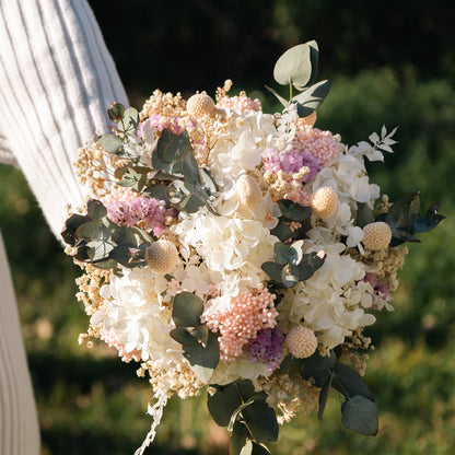 Bouquet of flowers held by a person with a blurred green background